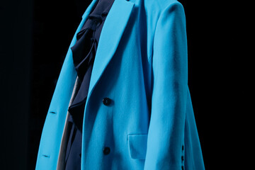 Bright blue classy jacket and silk dress on black background. 