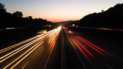 Long exposure photograph of a highway at dusk with streaks of light from passing vehicles.