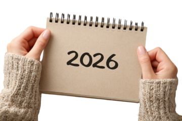 Hands holding a light brown notepad with the year 2026 written on it