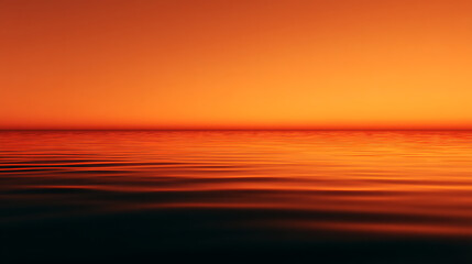 Obraz premium Orange sunset sky reflecting on the calm ocean water at dusk creating a serene and peaceful scene