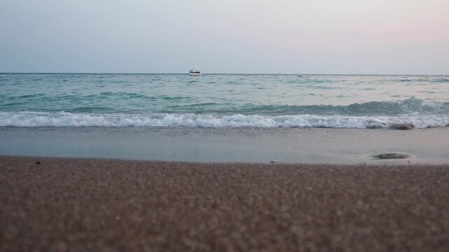 Gentle waves lap against the golden sands of Canj, Montenegro, as the morning sun rises over the tranquil Adriatic Sea, creating a peaceful atmosphere for beach lovers. Mediterranean