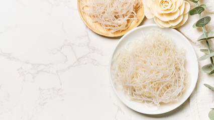 flat lay Korean glass noodle vermicelli for Japchae food in bowl on white marble table food...