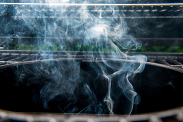 dym unoszący się nad rozpalonym grillem 
