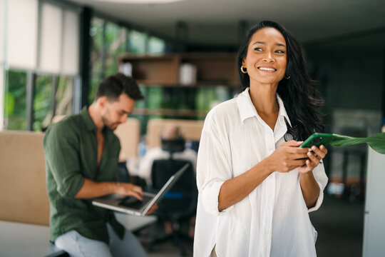 Busy smiling executive business team using digital devices in office. Diverse professional people