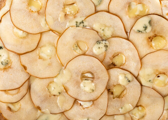 Sliced apples arranged in a circular pattern, topped with creamy cheese, showcasing a delicious gourmet dish perfect for culinary presentations and food photography