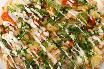 Delicious gourmet pizza topped with fresh greens, grilled chicken, cherry tomatoes, and drizzled...