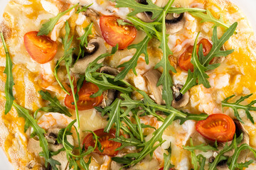 Delicious gourmet pizza topped with fresh arugula, cherry tomatoes, mushrooms, and melted cheese,...