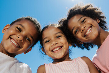 joyful children smiling under blue sky, enjoying a sunny day, capturing youthful innocence and happiness