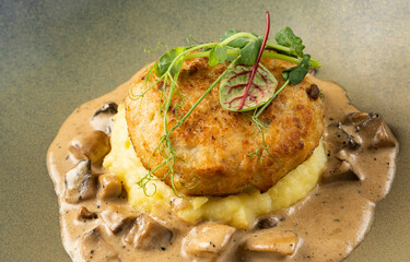 Gourmet dish featuring crispy potato cake atop creamy mashed potatoes, garnished with fresh herbs...