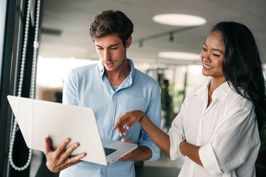 Group of young multi-ethnic startup business team collaborating on project in modern office