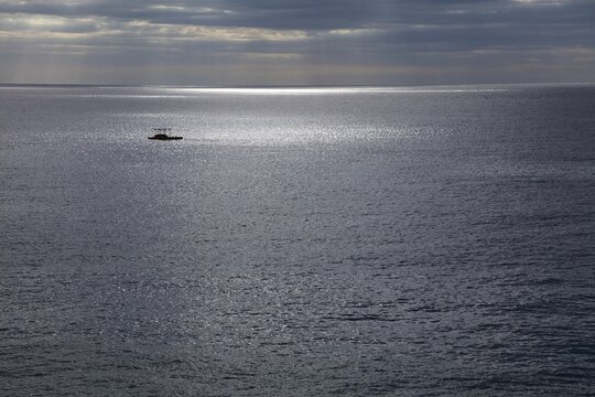 Ethereal atmosphere over Mediterranean Sea seen from Lloret de Mar, Spain. Silvery seascape with dramatic weather and melancholic, solemn mood.