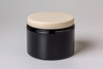 A dark glass jar with a light colored lid sits on a plain background