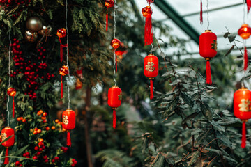 Details of red lanterns with golden characters of Chinese New Year hanging outside, Asian traditional holidays