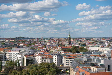 Fototapeta premium Cityscape with red roofs and a church steeple in the distance. Historical and modern architecture blend together in the Berlin skyline.
