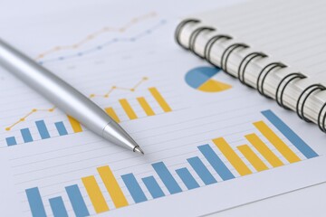 Financial Data Analysis: Close-up of Charts, Graphs, Pen, and Notebook for Business Strategy and Reporting