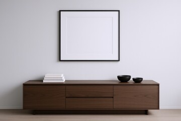 Modern Minimalist Interior with Blank Frame Above Wooden Cabinet, Featuring Books and Decorative Bowls