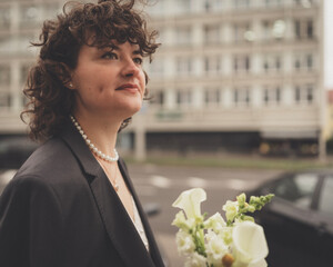 Confident bride holding a bouquet and looking ahead with a determined expression.  Love,...