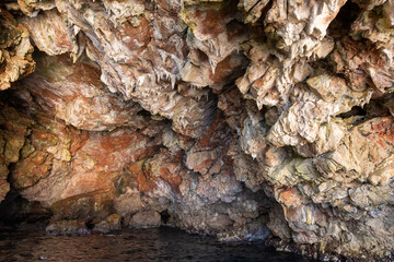 A textured, rocky cave interior with unique natural formations and vivid colors