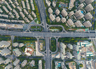 Aerial top down view of a busy junction reveals a multitude of vehicles traveling on various...