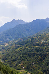 Fototapeta premium Lush green forests cover the mountainous landscape under a bright sky
