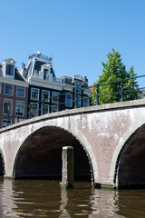 Naklejka premium Beautiful cityscape view of the city of Amsterdam as seen from the canal and bridges.