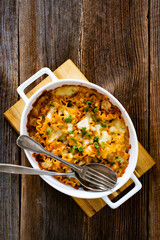 Pasta casserole with marinara sauce and mozzarella cheese on wooden table