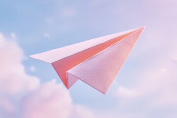 Pink paper airplane flying against pastel sky with soft dreamy clouds