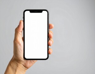 Hand holding modern smartphone with blank white screen against neutral gray backdrop, showcasing technology and connectivity in a simple, minimalist style.