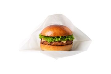 Classic beef burger with lettuce and cheese on sesame bun wrapped in white paper, isolated on a transparent background