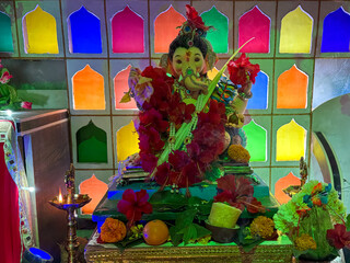 A brightly decorated idol of Lord Ganesha creates a festive and devotional atmosphere for the...