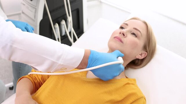 Woman patient receives thyroid diagnostics. Treatment of thyrotoxicosis, and hypothyroidism. Ultrasound diagnostics of endocrine system and thyroid