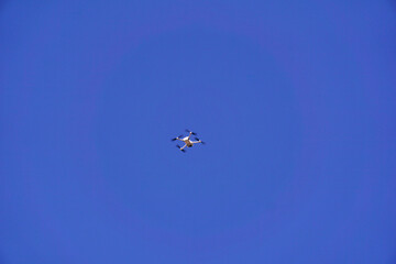 the drone flies against the background of the blue sky