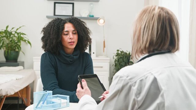 Experienced Doctor Consults Diverse Female Patient About Her Throat Health and Medical Concerns