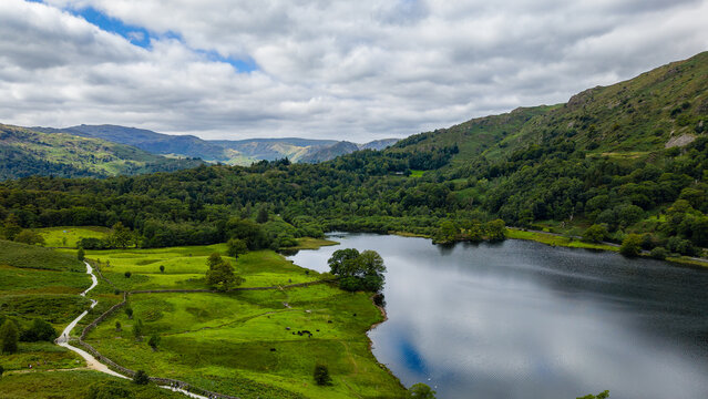 Cloudy day over the tranquil Rydal Water and wooded hillsides in the Lake District