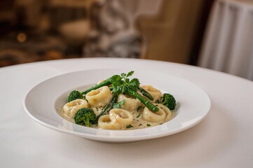 Pasta filled with cheese in creamy sauce garnished with fresh greens