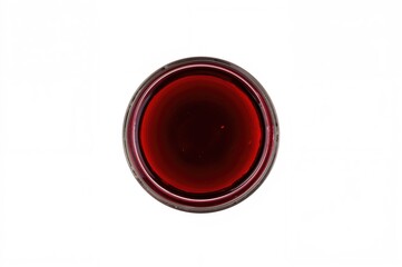Overhead shot of a glass filled with aged red wine against a white backdrop