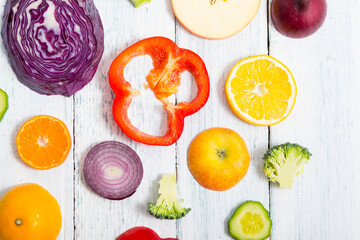 sliced fruit and vegetable circles on white wood table