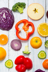 sliced fruit and vegetable circles on white wood table