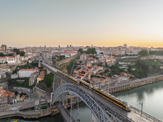 Obraz premium Sunrise View of Porto City, Portugal. Dom Luis I Bridge and Metro Train on It. Drone, Golden Hour