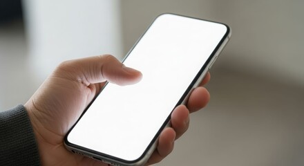 A close-up view of a hand holding a smartphone with a blank, glowing screen.