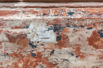 A rustic background featuring a close-up view of a textured, weathered wall with peeling paint.