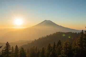 Fototapeta premium Golden hues of dawn over a scenic mountain landscape with trees and natural beauty