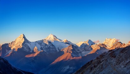 mountain range at sunrise with snowy peaks and clear blue sky