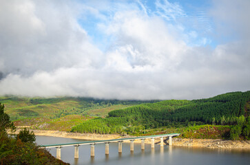 Fototapeta premium A modern bridge crossing a beautiful lake in the mountains The Power of Human Engineering
