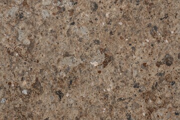 Close-up of a coarse, uneven stone surface displaying a mix of brown and gray hues
