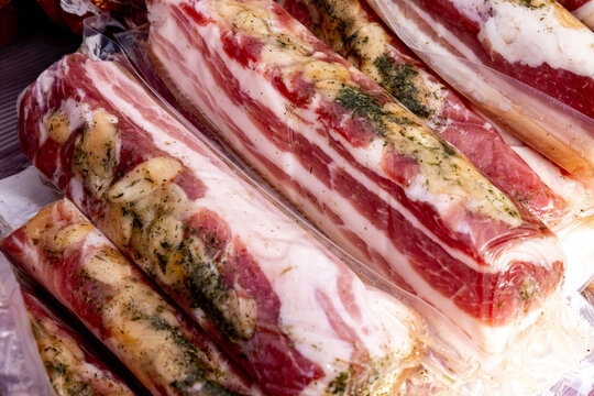 Savory cured meats prepared with herbs and spices, ready for sale at a local market in autumn