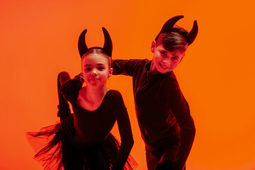 Children skaters dressed as devils perform on ice for Halloween