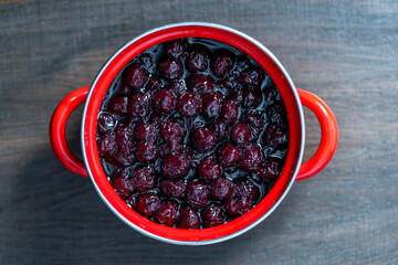 Fresh red cherries piled high showcasing the bounty of summer harvest. Glossy cherries arranged in saucepan. Juicy cherry symbolizing the sweetness and richness of life, closeup