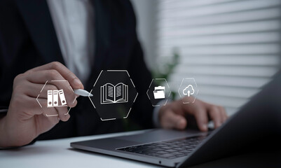 Businessman using digital pen and laptop with document book folder and cloud storage icons. Concept of digital library online archive knowledge management and business information system © ACHJIMA