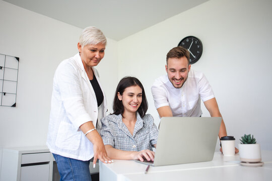 Diverse business team working together on laptop in office, brainstorming ideas and collaborating on project strategy, teamwork and corporate success concept.
